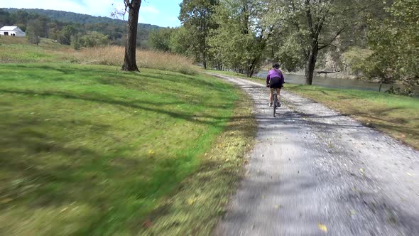 Going fast around a curve with a woman in front and a river in the background.