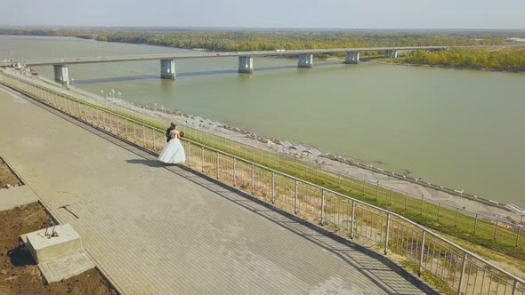 Just Married Couple on Hilly Embankment Near River Aerial