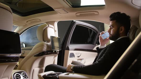 Young Male Businessman Talking on the Phone in a Luxury Car