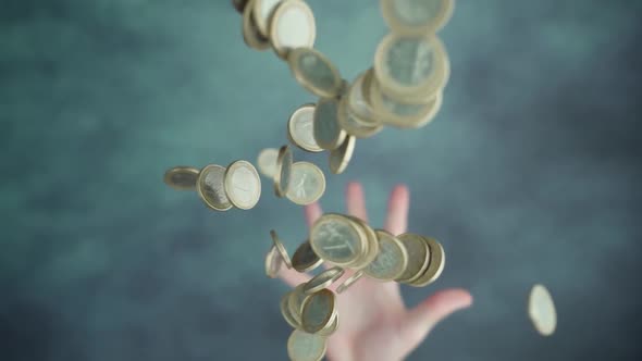 Throwing Up Handful of Coins Above Green Table Surface