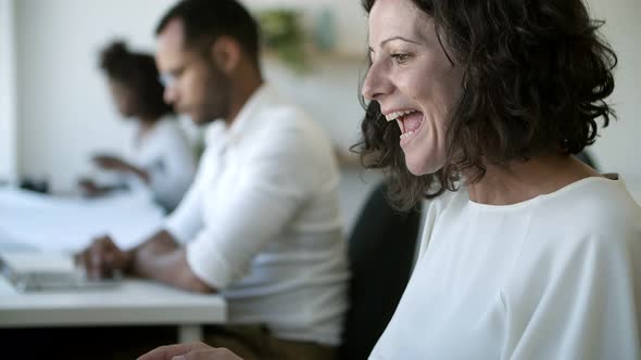 Curly Woman Using Laptop Then Giving High Five To Colleagues