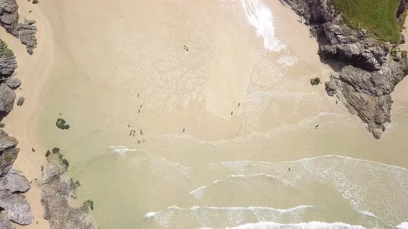 Ocean Waves On Poly Joke Beach In Summer - Tourists At Sandy Beach Tucked Into A Deep Cove At Low Ti