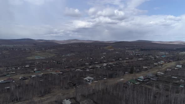 Aerial view of city with old one-story houses. Cloudy spring day