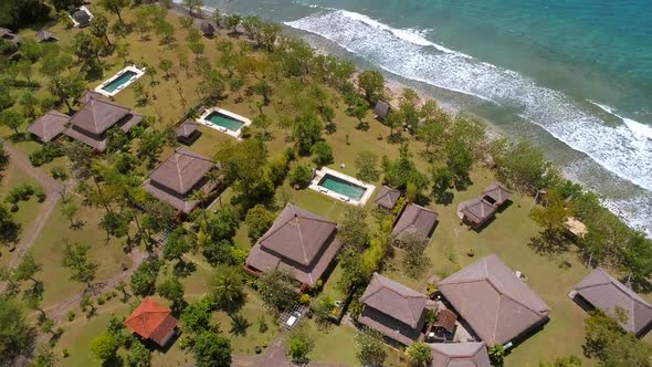 Aerial view of luxury bungalows near the coast of Bali island, Indonesia.