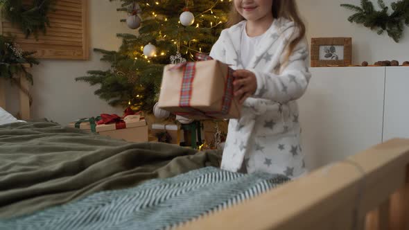 Little girl opening the Christmas present. Shot with RED helium camera in 8K