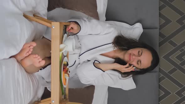 Female Talking By Phone While Have Breakfast