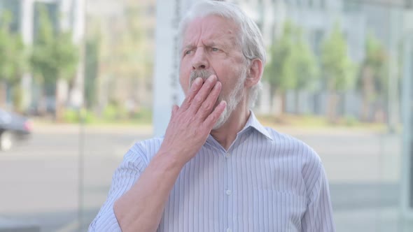 Portrait of Sleepy Old Man Yawning Outdoor