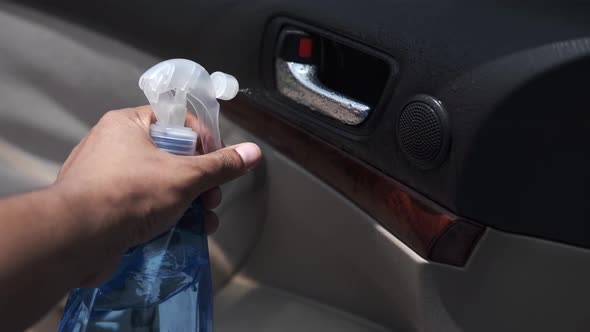 Hand in Spry Bottle Cleaning Car Door Knob