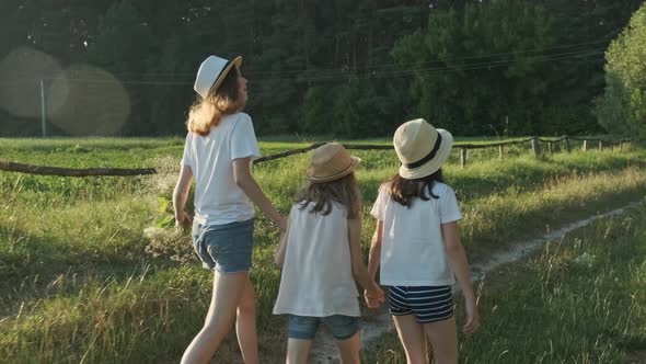 Children Three Girls in Hats Holding Hands Running Back Along Rural Country Road