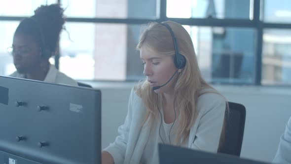 Focused Fair Haired Operator Headset Taking Call