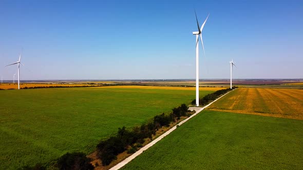 Aerial drone view of a flying over the wind turbine and agricultural fields