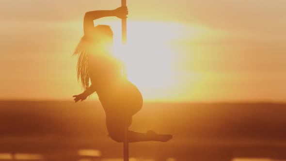 Pole Dance on Bright Sunset - Acrobatic Woman Spinning on the Dancing Pole
