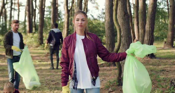 Girl with Rubbish Bag During Collecting it All Over the Park Together