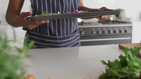 Mid section of african american woman preparing dinner in kitchen