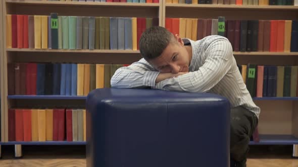 Tired young man in the library