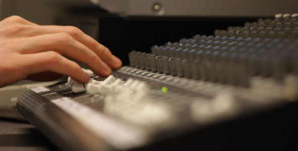 Sound Designer Working on a Mixing Board
