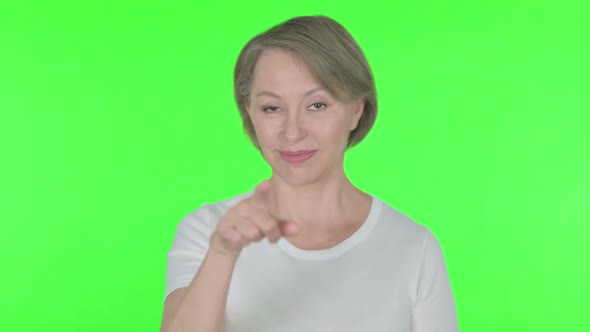 Old Woman Pointing at the Camera on Green Background