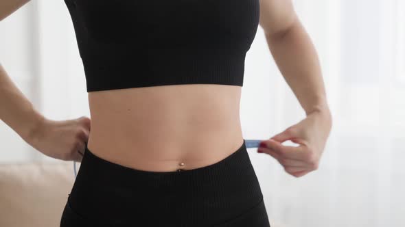 Young Woman Measuring Her Waist