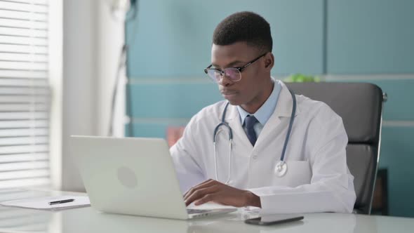 Young African Doctor Shaking Head As No Sign While Using Laptop in Office