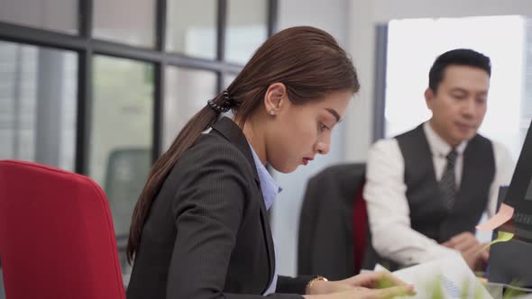 Asian young business woman typing on keyboard brainstorming and working on project in office.