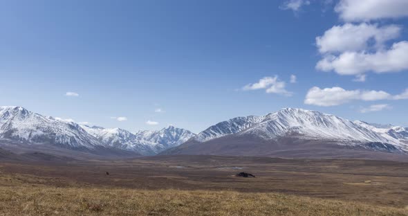 Timelapse of Sun Movement on Crystal Clear Sky with Clouds Over Snow Mountain Top