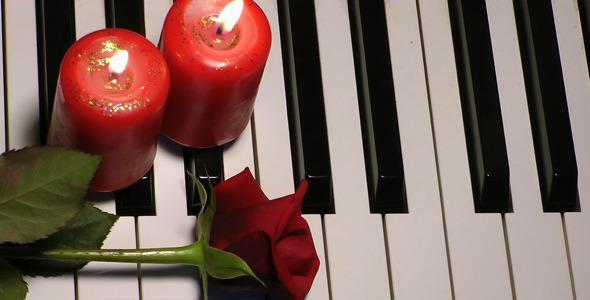 Rose and Candle on Piano Keys