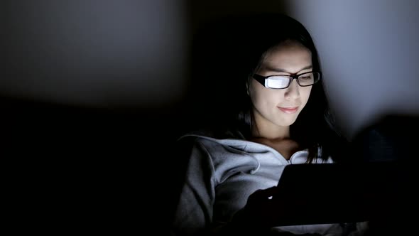 Woman using tablet at night 