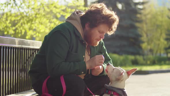 Man Giving Treats to Dog in Park