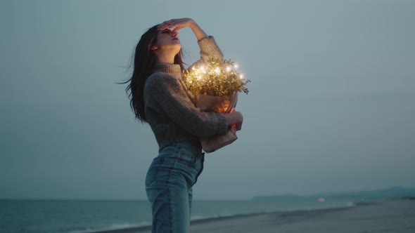 Happy Young Girl Enjoys Life on the Beach with Colorful Lights on Bag