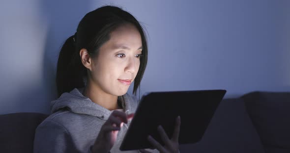 Woman watching on tablet computer at home