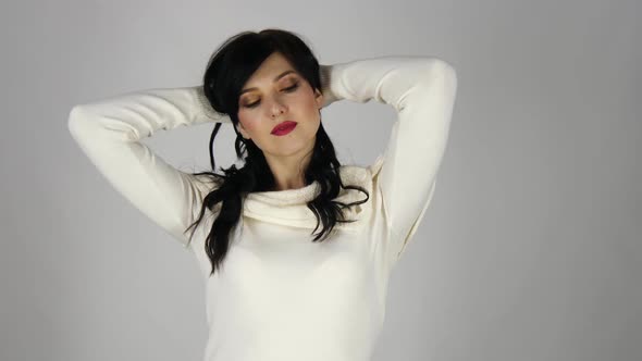 Young Woman with a Black Hair Having Fun Smiling and Touching Her Hair in Studio