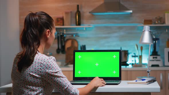 Business Woman Looking at Green Screen Laptop