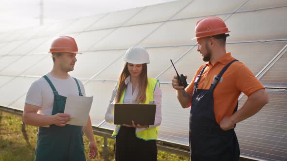 Three Solar Energy Specialists Walking at a Solar Power Facility