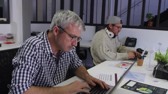 Two Caucasian men working in a creative office