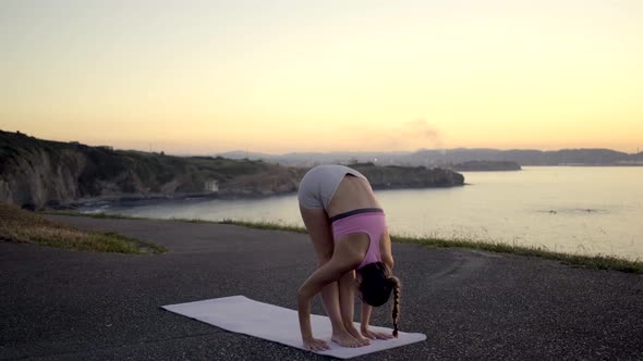 Young woman practising yoga during sunrise