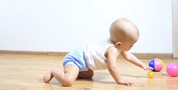 Little Baby Crawling on Floor to a Toy