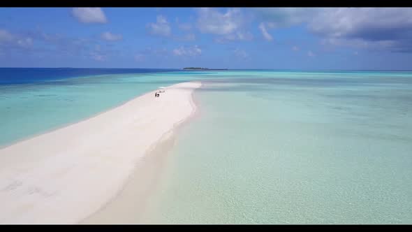 Aerial flying over panorama of tranquil tourist beach time by aqua blue water with white sand backgr