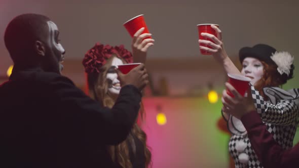 Friends in Halloween Costumes Toasting at Party