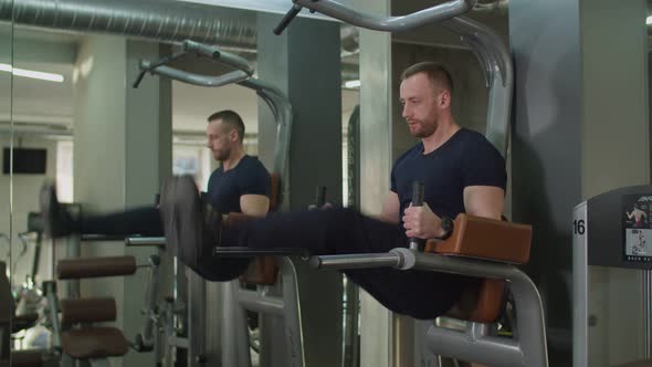 Fit Man Performing Hanging Leg Raises Exercise