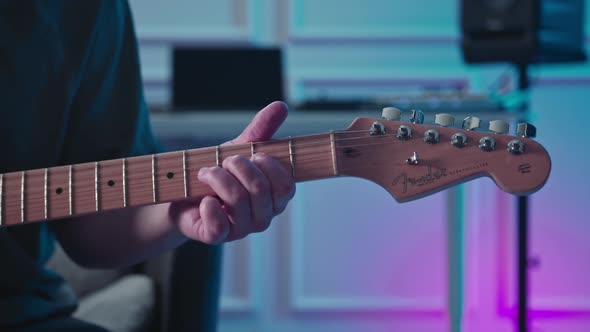 Man plays guitar in professional music studio. Man plays a musical instrument. Musician records