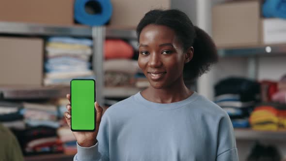 Portrait View of the Multiracial Woman Holding Smartphone with Green Mock Up Screen and Looking to