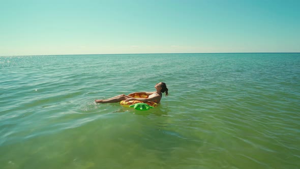 Top View Happy Smiling Young Woman in Sunglasses Swimming on Inflatable Pineapple Floating Ring in