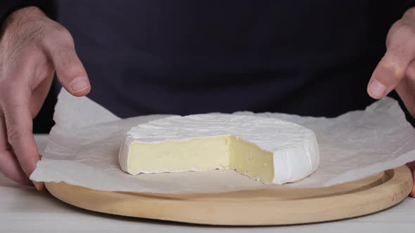 Chef puts on table plate with delicious soft cheese Camembert