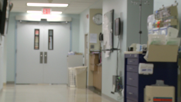 Member Of Hospital Staff Checks Information Board