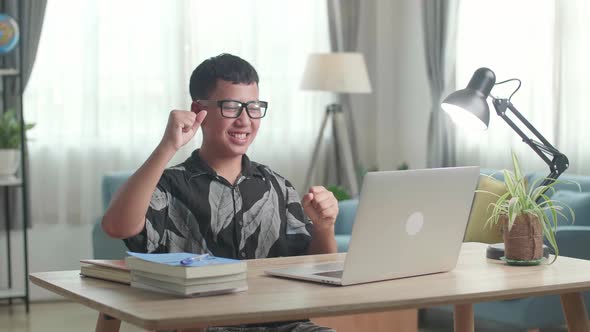 Young Asia Boy Student Celebrating With Laptop Computer At Home