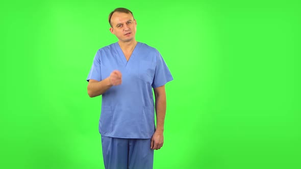 Medical Man Threatens with a Finger and Waves Her Head Negatively. Green Screen