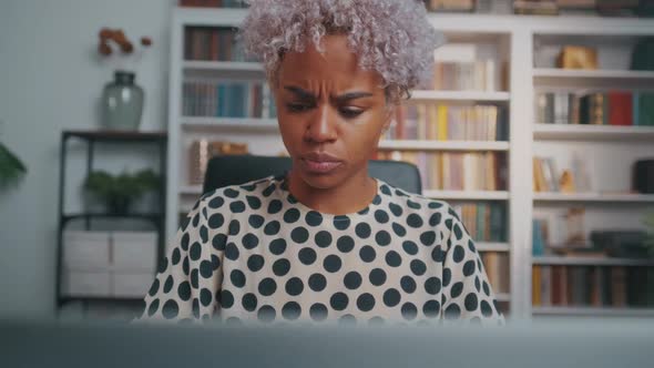 Young African American Woman Closes Laptop and Meditates Sits at Office Desk