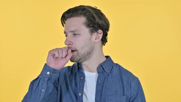 Portrait of Sick Young Man Coughing on Yellow Background