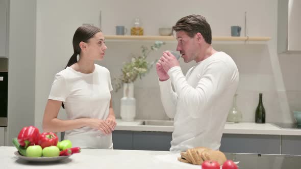 Mixed Race Couple Talking While Standing in Kitchen