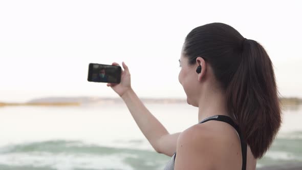 The Girl is Talking on Video Chat with a Friend who Runs in a Medical Mask